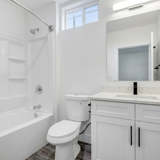 Bathroom with vanity and tub/shower combination at The Bungalows